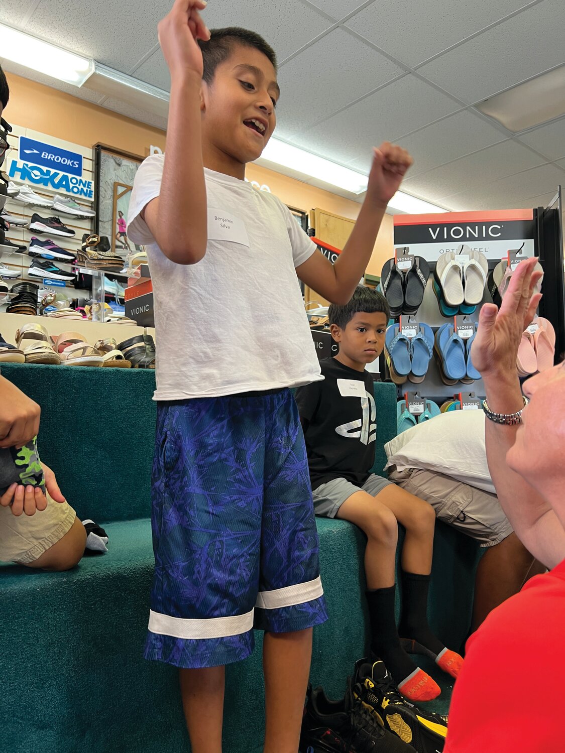 Guadalupe Center student Benjamin reacts after finding a new pair of shoes at Snyderman Shoes of Naples.